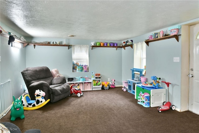 rec room featuring carpet and a textured ceiling