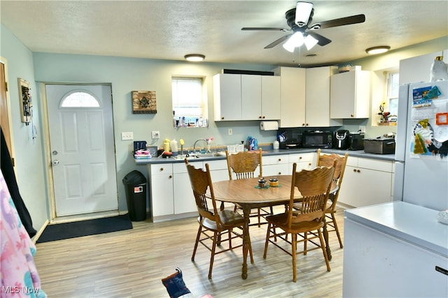 kitchen with light wood-type flooring, white cabinets, ceiling fan, and white refrigerator