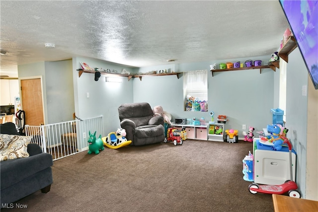 playroom featuring a textured ceiling and carpet flooring