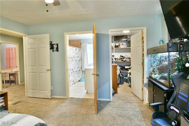 interior space featuring ceiling fan, light colored carpet, and ensuite bathroom