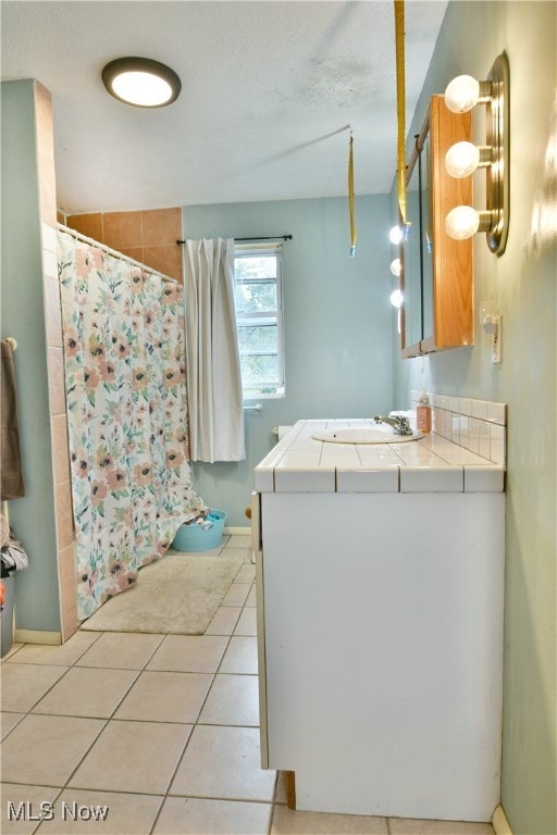 bathroom with tile patterned floors, vanity, and curtained shower