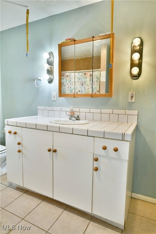 bathroom featuring tile patterned flooring, vanity, and toilet