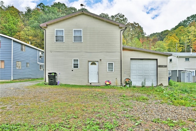 back of house featuring a storage shed