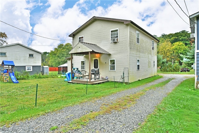 view of front of house with a playground, a front yard, and a wooden deck