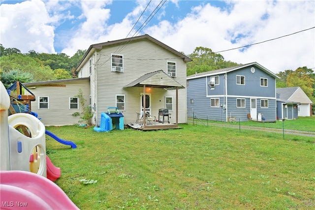 back of house with a playground, a yard, and a wooden deck