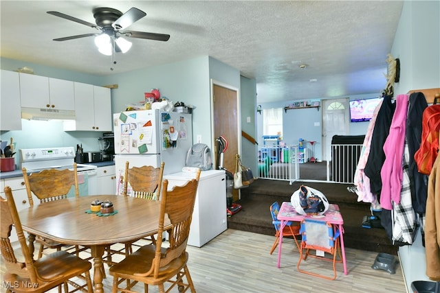 dining room with light wood-type flooring, ceiling fan, and a textured ceiling