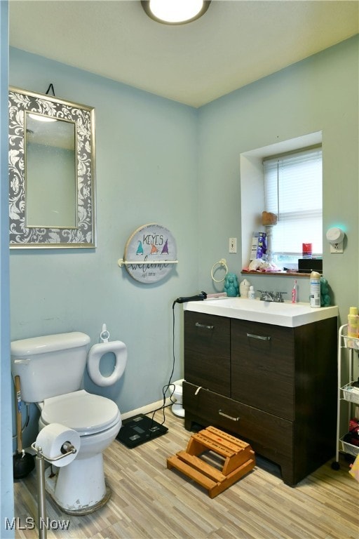 bathroom with vanity, hardwood / wood-style floors, and toilet