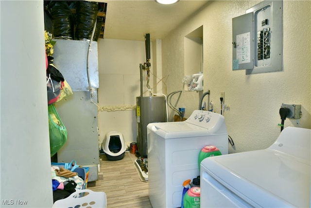 laundry area with electric panel, light hardwood / wood-style floors, independent washer and dryer, and water heater