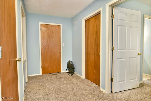 hall with light colored carpet