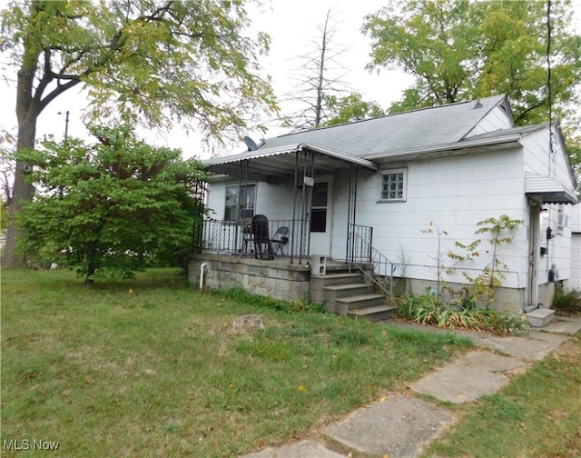 rear view of property featuring a yard