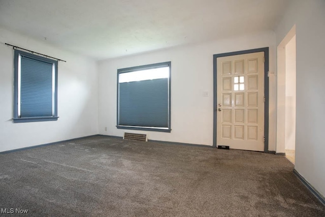 empty room featuring dark carpet