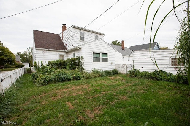 rear view of house featuring a lawn