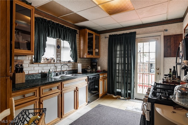 kitchen with light tile patterned floors, sink, a paneled ceiling, dishwasher, and decorative backsplash