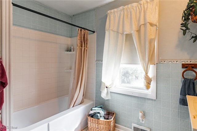 bathroom featuring tile walls and shower / tub combo with curtain