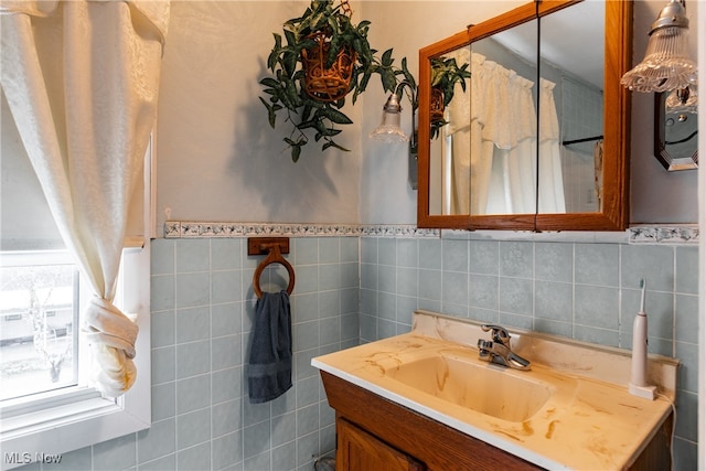 bathroom with vanity and tile walls