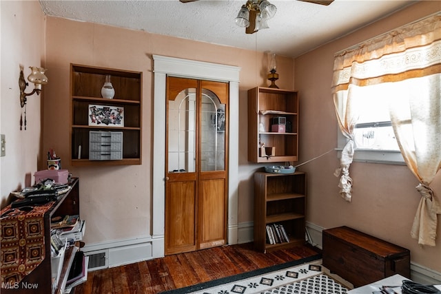 misc room featuring ceiling fan, hardwood / wood-style flooring, and a textured ceiling