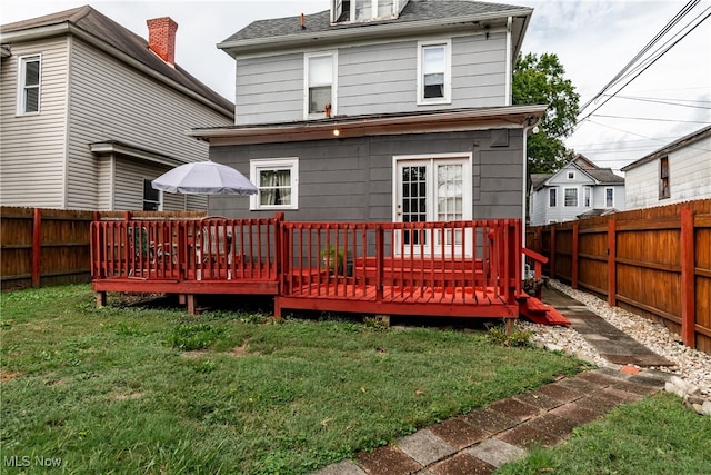 back of property featuring a deck and a yard