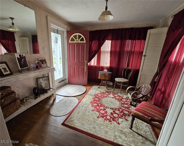 foyer with light hardwood / wood-style floors, crown molding, and a textured ceiling