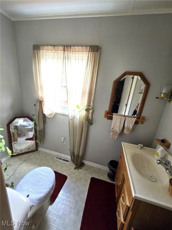 bathroom featuring toilet, vanity, and crown molding