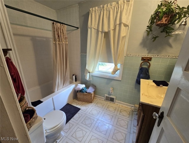 full bathroom with shower / bath combination with curtain, tile walls, vanity, and toilet