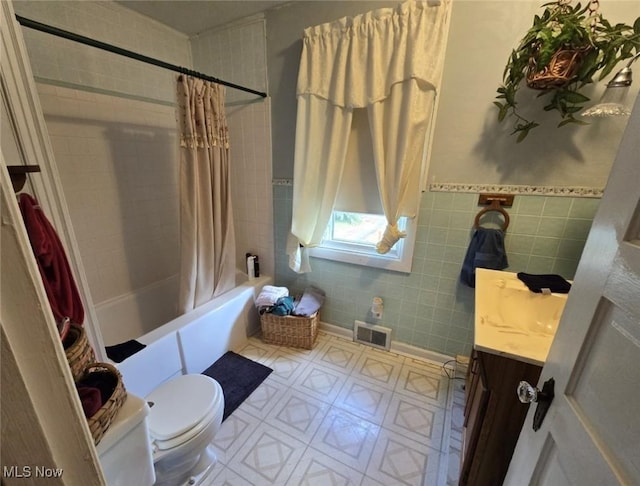 1808 Covert St, Parkersburg, WV 26101 - full bathroom featuring vanity, visible vents, toilet, tile walls, and shower / tub combo
