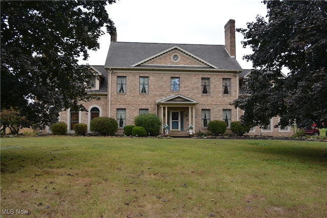 colonial inspired home featuring a front lawn