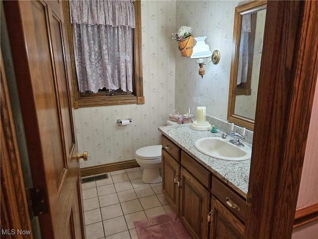 bathroom with toilet, tile patterned floors, and vanity