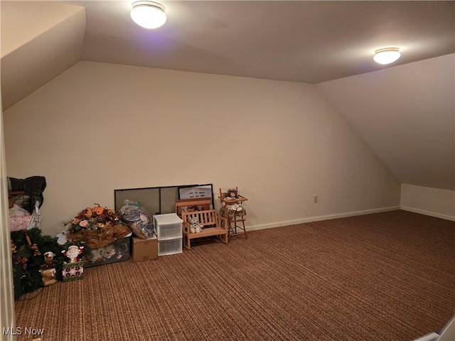 bonus room featuring dark colored carpet and vaulted ceiling