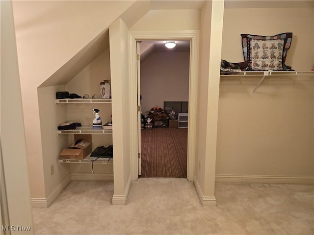 walk in closet featuring lofted ceiling and light carpet