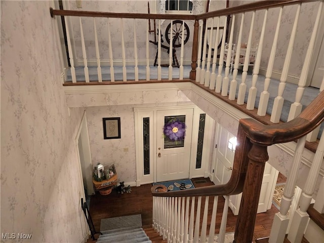 stairway featuring a towering ceiling and hardwood / wood-style floors