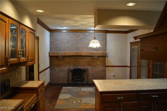 living room with a brick fireplace, crown molding, and dark hardwood / wood-style floors