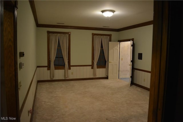 carpeted spare room featuring crown molding