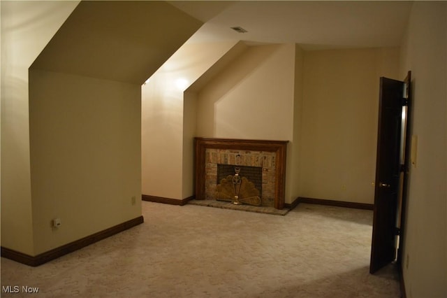 unfurnished living room with light colored carpet and a brick fireplace