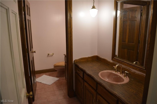 bathroom featuring toilet, tile patterned flooring, and vanity