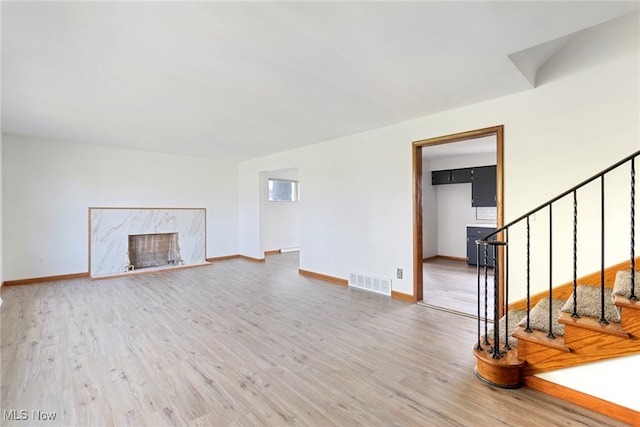 unfurnished living room with hardwood / wood-style floors and a premium fireplace