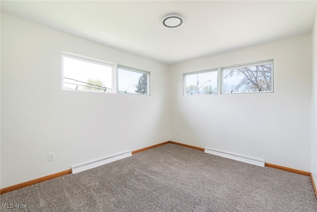 carpeted spare room featuring a wealth of natural light and a baseboard radiator