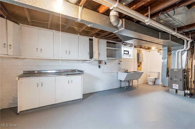 basement featuring heating unit and sink