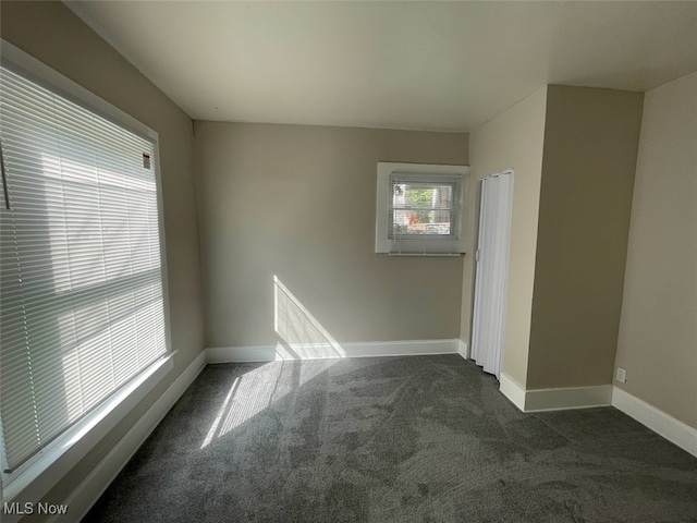 unfurnished room with dark carpet