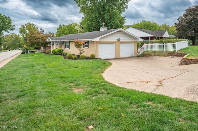 ranch-style home with driveway, a chimney, fence, a front yard, and brick siding