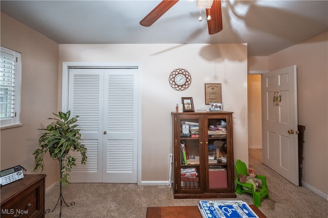 interior space with carpet and ceiling fan