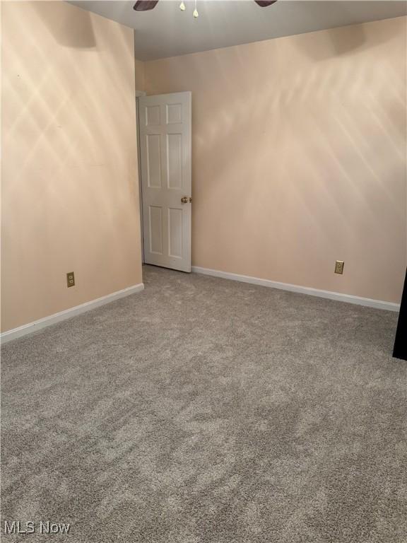 carpeted spare room featuring ceiling fan