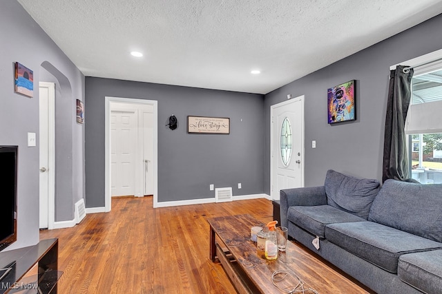 living room featuring hardwood / wood-style flooring and a textured ceiling