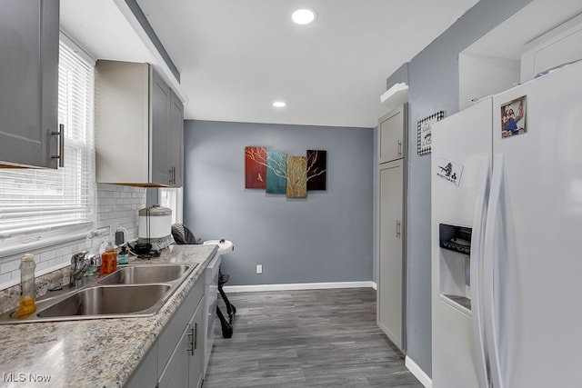 kitchen featuring a healthy amount of sunlight, sink, gray cabinetry, and white refrigerator with ice dispenser