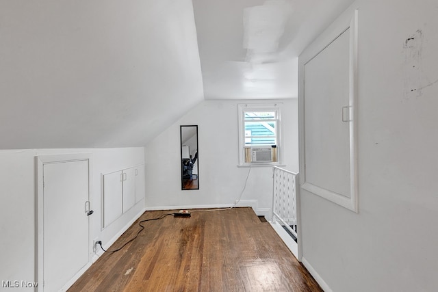 additional living space with lofted ceiling, cooling unit, and hardwood / wood-style flooring