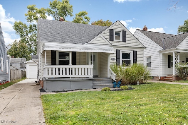 view of front of home featuring a garage, a porch, an outdoor structure, and a front lawn