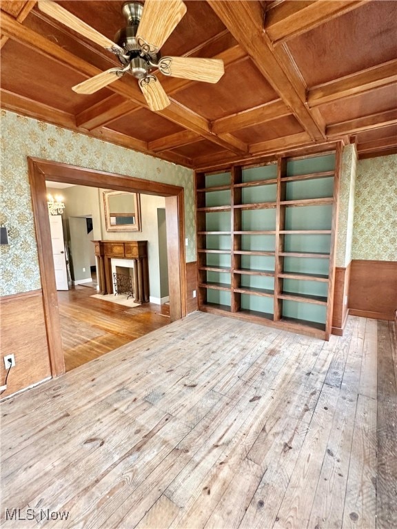 unfurnished living room with ceiling fan, coffered ceiling, and wood-type flooring