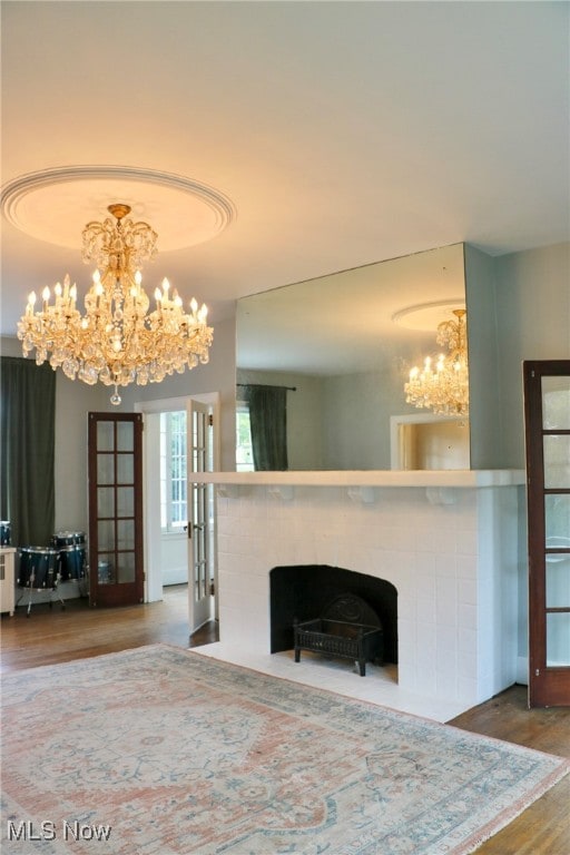 living room featuring a chandelier, hardwood / wood-style flooring, and french doors