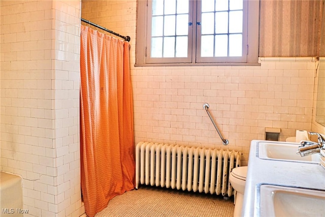 full bathroom with toilet, a shower with curtain, radiator heating unit, tile patterned flooring, and tile walls