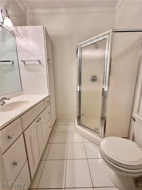 bathroom featuring vanity, walk in shower, crown molding, toilet, and tile patterned floors