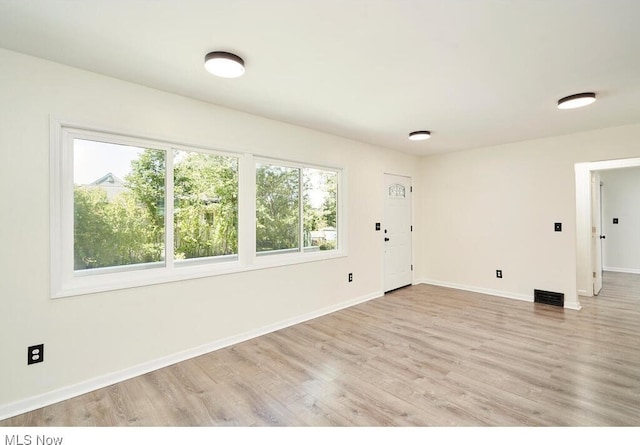 unfurnished room with light hardwood / wood-style floors and a wealth of natural light